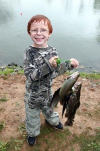 happy-boy-with-glasses-on-lake-shelbyville-fishing-proudly-holding-a-fish-catch-200x300